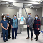 Hospital staff centered around a piece of equipment