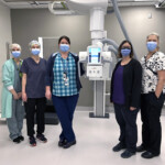 Hospital staff centered around a piece of equipment